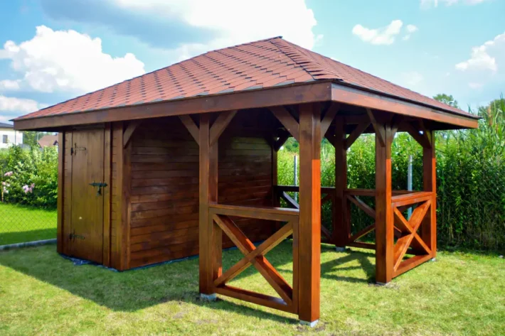 a18-3-stylowa-drewniana-altana-ogrodowa Altana A18 to wyjątkowe połączenie funkcjonalności i estetyki, idealnie wpisujące się w każdą przestrzeń ogrodową. Dzięki przestronnej konstrukcji, która łączy altanę o wymiarach 3,00m x 3,50m z domkiem o wymiarach 1,80m x 3,50m, stanowi idealne miejsce do relaksu, przechowywania i spotkań na świeżym powietrzu.