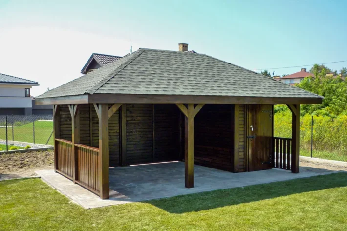 a19-2-stylowa-drewniana-altana-ogrodowa Altana A19 to elegancka i funkcjonalna konstrukcja, która doskonale łączy przestrzeń wypoczynkową z praktycznym domkiem, idealnym do przechowywania lub dodatkowego użytku. Całkowity wymiar altany wynosi 6,00m x 4,00m, z czego altana zajmuje 4,40m x 4,00m, a domek 1,60m x 3,00m. Przed domkiem znajduje się uroczy tarasik o wymiarach 1,60m x 1,00m, który stanowi doskonałe miejsce na relaks.