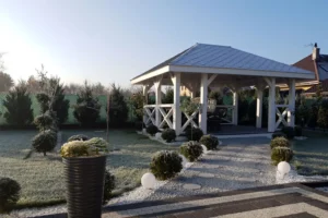 Altana A17 to elegancka, przestronna konstrukcja, która doskonale wpisuje się w aranżację ogrodu lub działki, oferując idealne miejsce do relaksu na świeżym powietrzu. Dzięki wymiarom 3,60m x 5,80m, altana zapewnia komfortową przestrzeń do spędzania czasu z rodziną i przyjaciółmi. Możliwość modyfikacji wymiarów pozwala dostosować altanę do indywidualnych potrzeb i dostępnej przestrzeni.