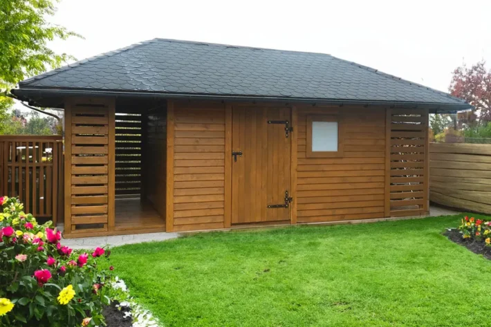 Domek narzędziowy D23 to praktyczna i trwała konstrukcja, idealna do przechowywania narzędzi, drewna opałowego oraz innych sprzętów ogrodowych. Dzięki dużym wymiarom 6,50m x 3,00m, domek oferuje przestronne pomieszczenie gospodarcze oraz dodatkowe zadaszenie na opał, co czyni go wszechstronnym rozwiązaniem dla każdego ogrodu.