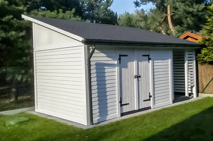 Domek narzędziowy D28 to doskonałe rozwiązanie dla osób szukających funkcjonalnej przestrzeni do przechowywania narzędzi, sprzętu ogrodowego oraz drewna opałowego. Jego przemyślana konstrukcja o wymiarach 3,00m x 6,00m, w tym 4,00m x 3,00m na pomieszczenie gospodarcze i 2,00m x 3,00m na zadaszenie na opał, zapewnia wystarczająco dużo miejsca na wszystkie potrzebne przedmioty.