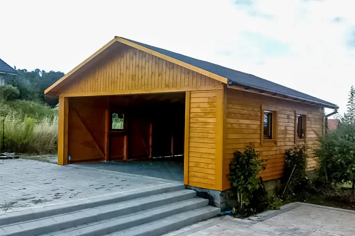 Garaż G4 to nowoczesne i funkcjonalne rozwiązanie, które idealnie sprawdzi się jako przestrzeń do przechowywania pojazdów, narzędzi oraz sprzętów ogrodowych. Dzięki dużym wymiarom 5,00m x 7,00m, garaż zapewnia komfortową przestrzeń użytkową.