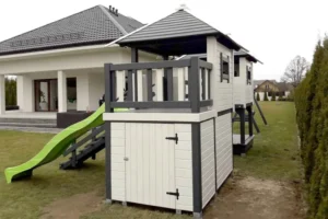 Plac zabaw P25 to kompletny, rozbudowany zestaw, który zapewnia dzieciom wiele możliwości aktywnej i bezpiecznej zabawy na świeżym powietrzu. Konstrukcja składa się z dwóch domków, tarasu, huśtawki oraz wielu innych atrakcji, które wspierają rozwój motoryczny oraz wyobraźnię. Wymiary domku wynoszą 5,00m x 3,80m, a huśtawki 1,70m x 3,35m, co pozwala na komfortową i bezpieczną zabawę dla dzieci w różnym wieku.