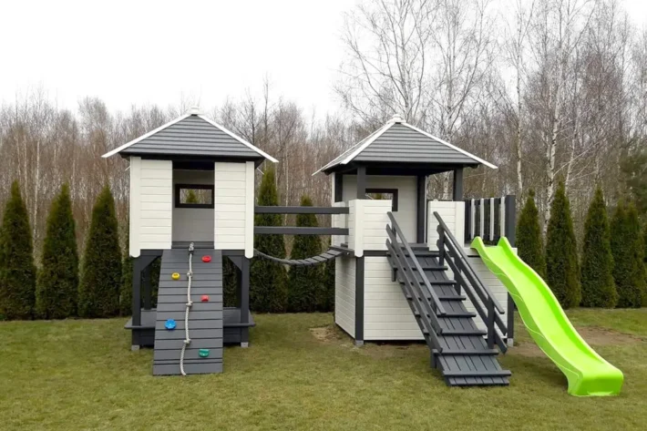 p25-3-funkcjonalny-plac-zabaw-dla-dzieci Plac zabaw P25 to kompletny, rozbudowany zestaw, który zapewnia dzieciom wiele możliwości aktywnej i bezpiecznej zabawy na świeżym powietrzu. Konstrukcja składa się z dwóch domków, tarasu, huśtawki oraz wielu innych atrakcji, które wspierają rozwój motoryczny oraz wyobraźnię. Wymiary domku wynoszą 5,00m x 3,80m, a huśtawki 1,70m x 3,35m, co pozwala na komfortową i bezpieczną zabawę dla dzieci w różnym wieku.